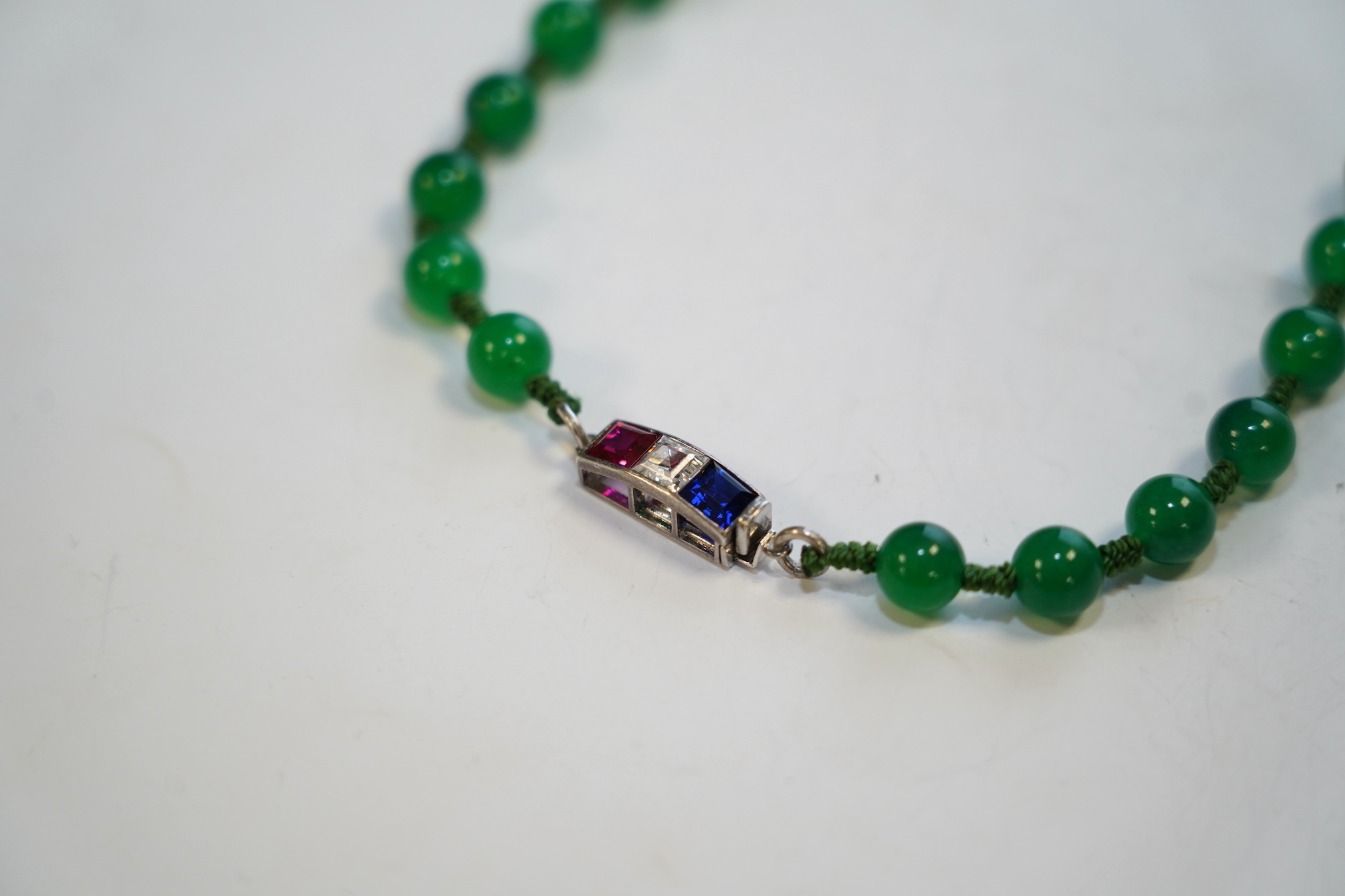 A single strand jadeite bead necklace, with simulated gemstone set clasp, 56cm. Condition - fair
